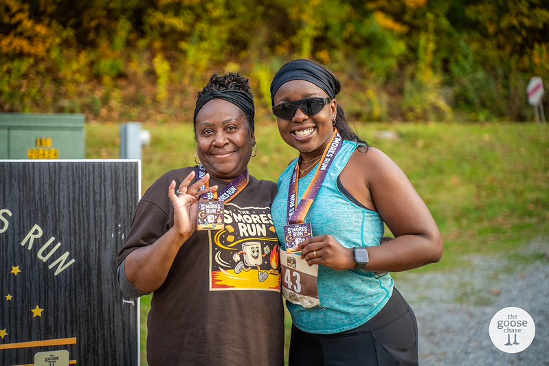 Two runners showing their S'mores Run finisher medals